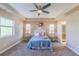 Bright bedroom with tray ceiling, large windows, and a queen-sized bed, all complemented by soft, neutral walls at 404 Dusk Ct, Erie, CO 80516