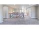 Bright hallway featuring carpeted floors and a wooden railing overlooking the staircase at 404 Dusk Ct, Erie, CO 80516
