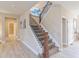 Hallway featuring wood-look flooring and a carpeted staircase with wood and iron railing at 404 Dusk Ct, Erie, CO 80516