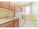 Well-lit laundry room with granite counters and plenty of cabinet storage at 404 Dusk Ct, Erie, CO 80516