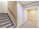 Carpeted staircase with wooden handrail leading to a finished basement room with neutral walls and lighting at 404 Dusk Ct, Erie, CO 80516
