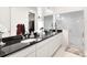 Contemporary bathroom featuring dual sinks, black countertops and a glass-enclosed shower at 17247 E 103Rd Ave, Commerce City, CO 80022