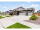 Attractive home showcasing gray siding, stone accents, a three-car garage, and mature landscaping at 17247 E 103Rd Ave, Commerce City, CO 80022