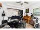 Bright home office features a sleek black desk, piano, and plenty of natural light at 17247 E 103Rd Ave, Commerce City, CO 80022