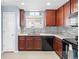 Modern kitchen with dark wood cabinets and granite countertops at 18861 E 58Th Ave # C, Denver, CO 80249