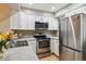 Bright kitchen features white cabinets, stainless steel appliances, and mosaic tile backsplash at 1612 S Idalia Cir # A, Aurora, CO 80017