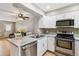 Modern kitchen with stainless steel appliances, white cabinets, and adjacent dining area at 1612 S Idalia Cir # A, Aurora, CO 80017