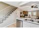 Bright kitchen with adjacent staircase and view to living room with brick fireplace at 1612 S Idalia Cir # A, Aurora, CO 80017