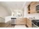 Modern kitchen with island, stainless steel appliances, and view to dining area at 5653 W 10Th Ave, Lakewood, CO 80214