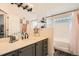 Elegant bathroom with a modern vanity, decorative mirror, and a bathtub-shower combination with stylish tile work at 3205 S Walden Ct # H, Aurora, CO 80013