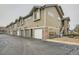 Exterior view of townhomes featuring garages, stone accents, and well-maintained landscaping at 3205 S Walden Ct # H, Aurora, CO 80013