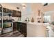 A well appointed kitchen and living room featuring modern appliances, dark cabinets, and an open-concept design at 3205 S Walden Ct # H, Aurora, CO 80013
