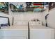 Bright laundry room with modern washer and dryer units and ample shelving at 3205 S Walden Ct # H, Aurora, CO 80013
