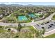 Scenic aerial view showcasing community tennis courts, pool, and green spaces with mountain backdrop at 8705 W Berry Ave # 204, Littleton, CO 80123