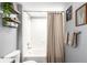 Bright bathroom featuring a shower/tub combo, shelves and updated fixtures at 8705 W Berry Ave # 204, Littleton, CO 80123