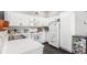 Kitchen with white cabinetry and modern appliances with view to the living room at 8705 W Berry Ave # 204, Littleton, CO 80123