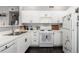 Bright kitchen with white cabinets, modern appliances, and dark hardwood floors at 8705 W Berry Ave # 204, Littleton, CO 80123