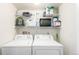 Functional laundry room with washer, dryer, and storage shelves at 8705 W Berry Ave # 204, Littleton, CO 80123