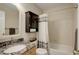 Bathroom featuring granite counters, wood cabinets and a shower over tub with shower curtain at 3207 Opal Ln, Superior, CO 80027
