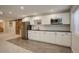 Finished basement kitchenette features a stainless steel refrigerator, white cabinetry and a barn door at 3207 Opal Ln, Superior, CO 80027