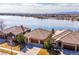 Stunning aerial view of lakeside homes with tile roofs and beautiful landscaping on a sunny day at 7700 W Grand Ave, Littleton, CO 80123