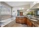 Well lit bathroom boasts double sinks with granite counters, tiled floors, and a soaking tub with decorative tile surround at 7700 W Grand Ave, Littleton, CO 80123