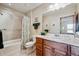 Bathroom with a tub and shower combo, wood vanity, and framed mirror provides a functional and stylish space at 7700 W Grand Ave, Littleton, CO 80123