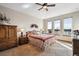 Bright bedroom with large windows overlooking the lake and a decorative ceiling fan at 7700 W Grand Ave, Littleton, CO 80123