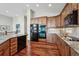 Modern kitchen with wood cabinets, stainless steel appliances, and hardwood flooring at 7700 W Grand Ave, Littleton, CO 80123