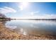 Serene lake view featuring calm waters, sandy shore, and clear blue skies at 7700 W Grand Ave, Littleton, CO 80123