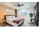 Bright main bedroom featuring wood accent wall, neutral carpet, and large window at 1137 Hummingbird Cir, Longmont, CO 80501