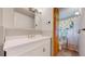 Bright bathroom vanity and sink with a mirror, and a toilet in the background with a decorative shower curtain at 8774 Princeton St, Westminster, CO 80031