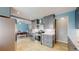 Modern kitchen with stainless steel appliances, granite countertops, gray cabinets, and wood-look tile flooring at 8774 Princeton St, Westminster, CO 80031