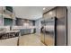 Updated kitchen with modern gray cabinets, stainless steel appliances, white tile backsplash and wood-look tile floors at 8774 Princeton St, Westminster, CO 80031