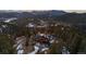 Stunning aerial view of a large home surrounded by lush trees in a serene setting at 4446 Songbird Ln, Evergreen, CO 80439