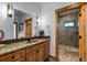 Bathroom features granite counters, wood cabinets, and tile floors with a walk-in shower at 4446 Songbird Ln, Evergreen, CO 80439