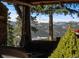 Inviting covered deck with comfortable seating and stunning mountain views at 4446 Songbird Ln, Evergreen, CO 80439