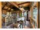 Dining area featuring a rustic table, wood beams, unique lighting, and stainless steel appliances at 4446 Songbird Ln, Evergreen, CO 80439