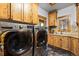 Convenient laundry room boasts knotty wood cabinetry and modern washer and dryer at 4446 Songbird Ln, Evergreen, CO 80439