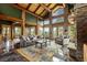 Open living space featuring a stone fireplace, wood beams, and gorgeous natural light at 4446 Songbird Ln, Evergreen, CO 80439