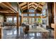 Bright, open-concept living room with wood beams, stone fireplace and mountain views at 4446 Songbird Ln, Evergreen, CO 80439