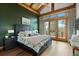 Spacious bedroom with vaulted ceilings, wooden beams, and a private balcony at 4446 Songbird Ln, Evergreen, CO 80439