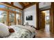 Serene bedroom featuring hardwood floors, a view of nature, and an ensuite bathroom at 4446 Songbird Ln, Evergreen, CO 80439