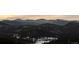 Scenic mountain range featuring snow-capped peaks in the distance against a colorful sky at 4446 Songbird Ln, Evergreen, CO 80439