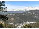 Breathtaking mountain view featuring snow-capped peaks and lush evergreen forest, framed by a clear blue sky at 4446 Songbird Ln, Evergreen, CO 80439