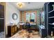 Cozy home office with patterned wallpaper, built-in shelving, and a view of the outdoors at 4446 Songbird Ln, Evergreen, CO 80439