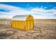Exterior view of a well-maintained yellow barn with a metal roof at 4820 S County Road 137, Bennett, CO 80102