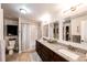 Bathroom featuring granite counters, dual sinks, dark wood cabinets, and tiled shower/tub combo at 4820 S County Road 137, Bennett, CO 80102