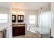 Bright bathroom with a soaking tub, dark wood cabinets, granite countertops, and tiled floor at 4820 S County Road 137, Bennett, CO 80102