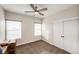 Bedroom with neutral walls, ceiling fan, carpet floor, two windows, and a closet with sliding doors at 4820 S County Road 137, Bennett, CO 80102